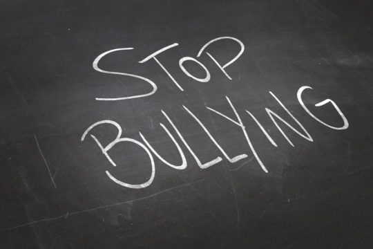 The words “stop bullying” written on a black chalkboard