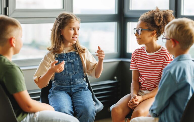 A group of students sit together in a circle and talk.