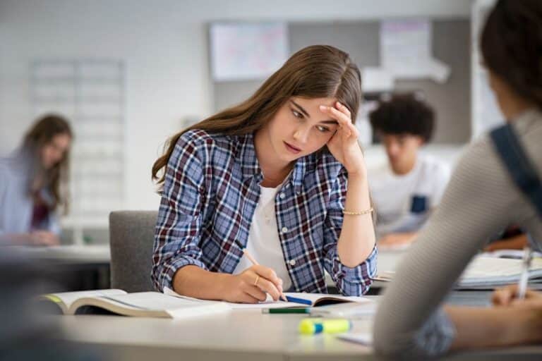 A student sits at her desk, trying to recall and remember information.