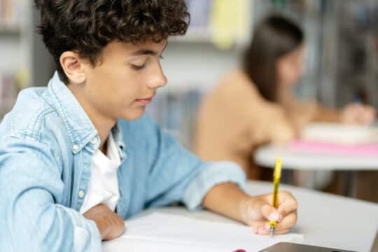 A portrait of a student focused and working on his school work.