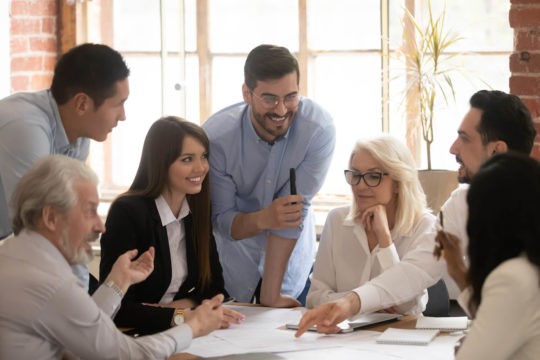 A group of diverse teachers talking at a table